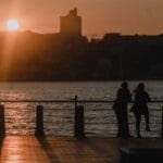 Para nad rzeką o zachodzie słońca na tle miejskiej panoramy
